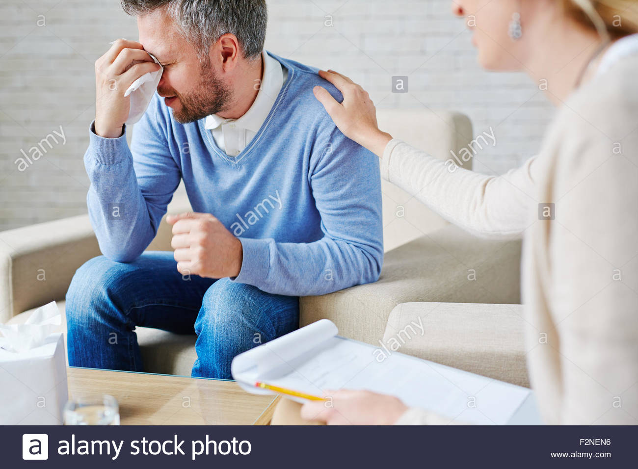 crying-man-with-handkerchief-sitting-by-his-psychologist-F2NEN6.jpg